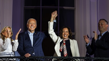 Biden and Harris raise their clasped hands above their heads as Jill Biden and Doug Emhoff stand by and clap.