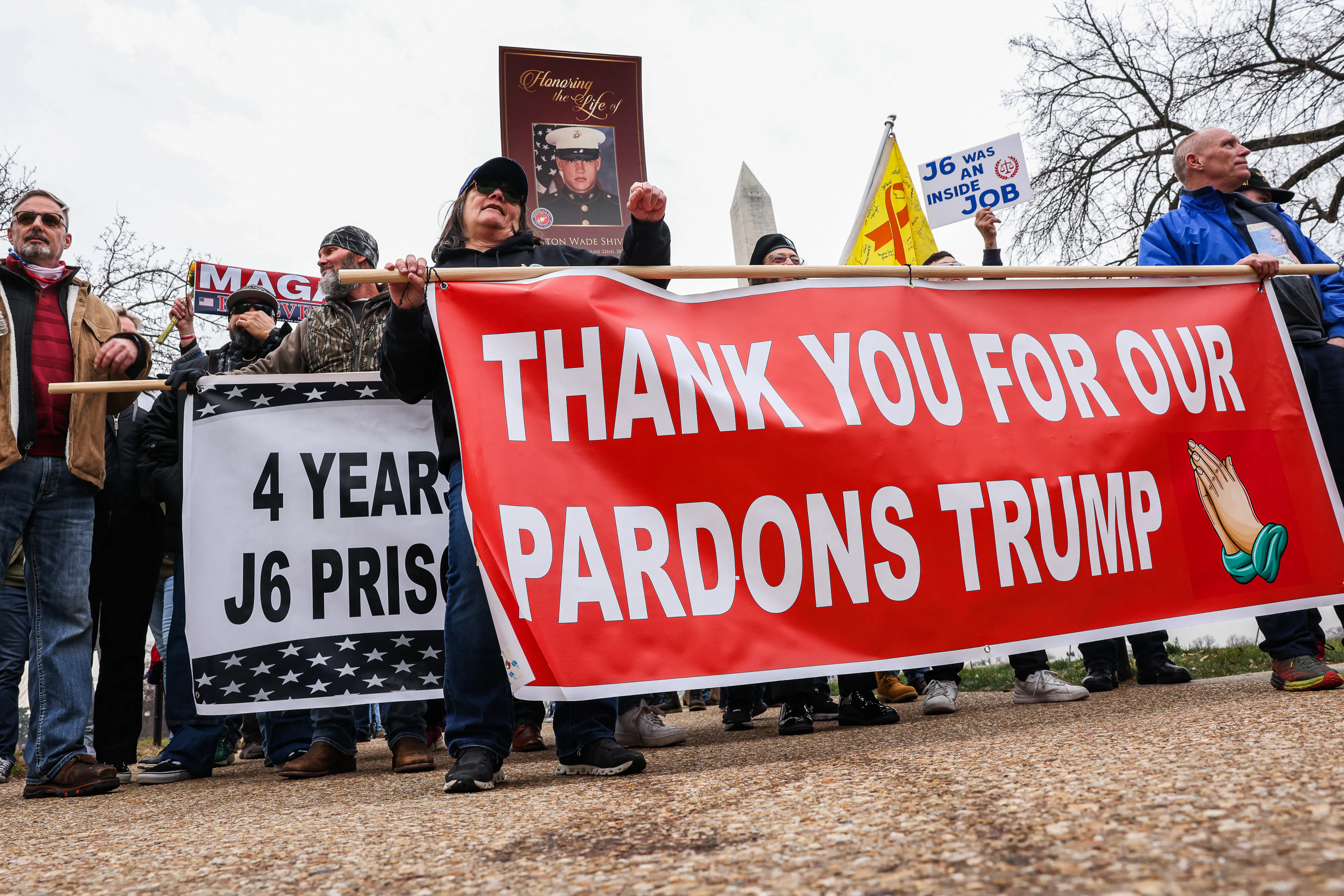 People hold a banner that says, "Thank you for our pardons Trump" during a five-year anniversary event for January 6 at the Capitol