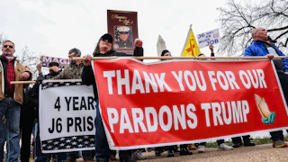 People hold a banner that says, "Thank you for our pardons Trump" during a five-year anniversary event for January 6 at the Capitol