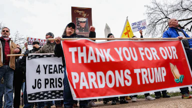 People hold a banner that says, "Thank you for our pardons Trump" during a five-year anniversary event for January 6 at the Capitol