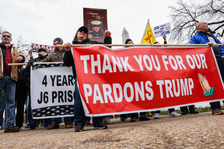 People hold a banner that says, "Thank you for our pardons Trump" during a five-year anniversary event for January 6 at the Capitol
