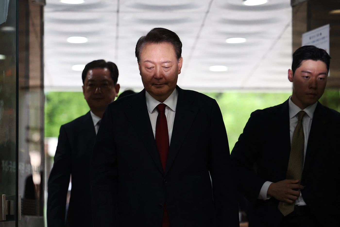 South Korean President Yoon Suk-yeol is pictured in July 2025, arriving at a court in Seoul to attend a hearing on his arrest warrant. impeached for having attempted to impose martial law in the country.. In February of this year, Seoul Central District Court sentenced him to life in prison for insurrection and related charges. 
