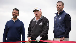 President Donald Trump and his sons Donald Trump Jr. (L) and Eric Trump hold a red ribbon