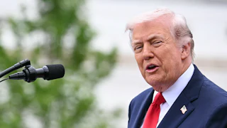President Donald Trump speaking at a microphone