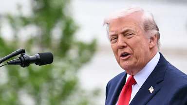 President Donald Trump speaking at a microphone
