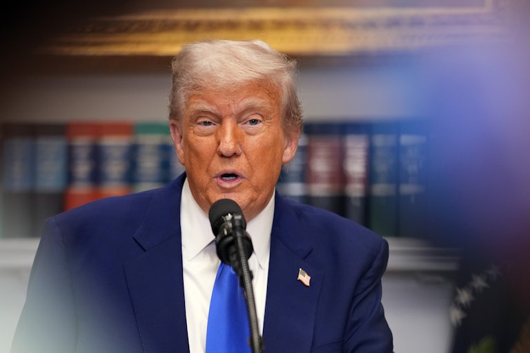 Donald Trump speaks into a microphone in the Oval Office