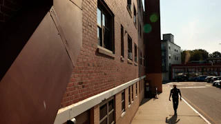 Boston Housing Authority Chief of Police and Public Safety Din Jenkins tours the South Street housing development in the Jamaica Plain neighborhood on June 11, 2025.