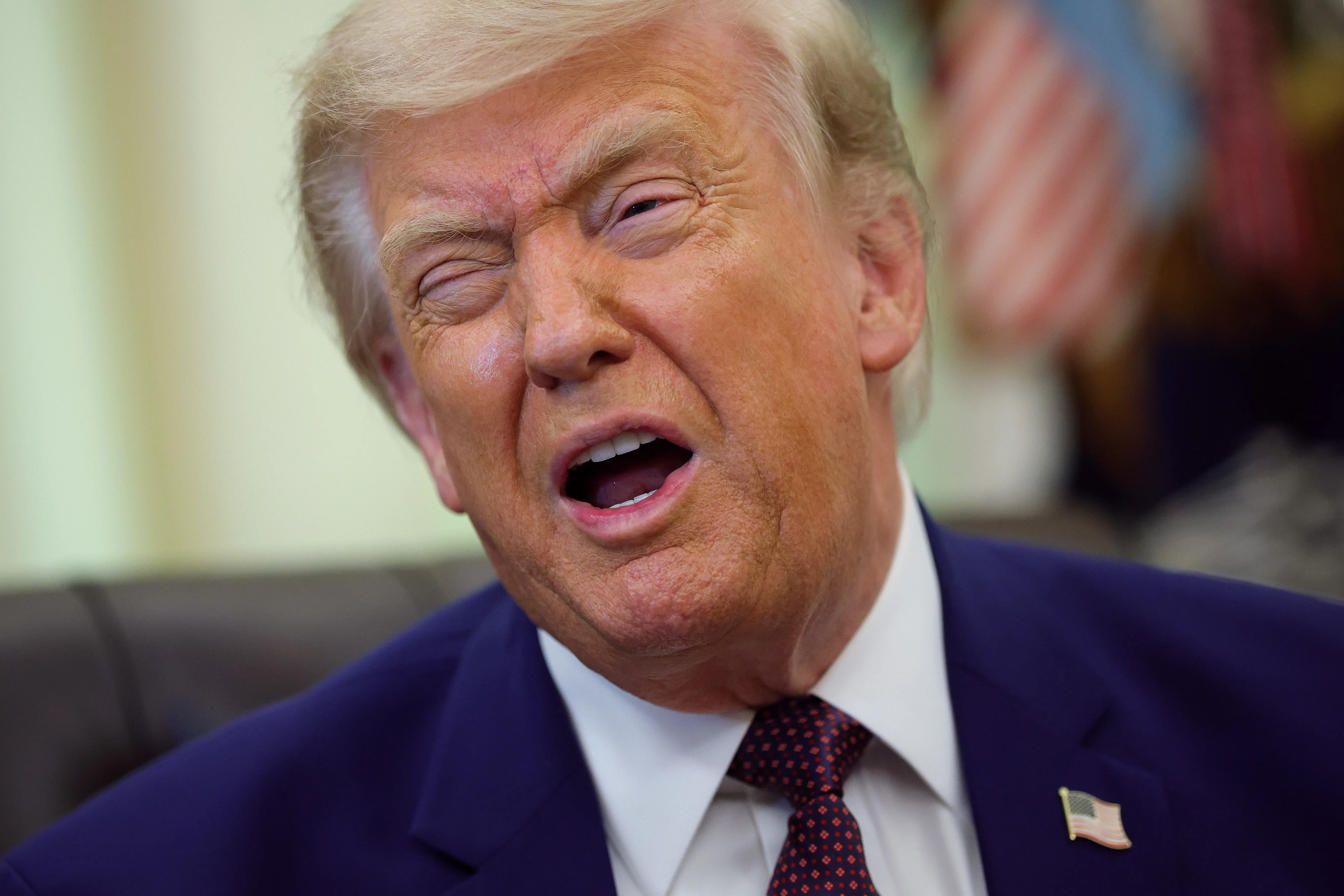 Donald Trump makes a winking face while speaking in the Oval Office