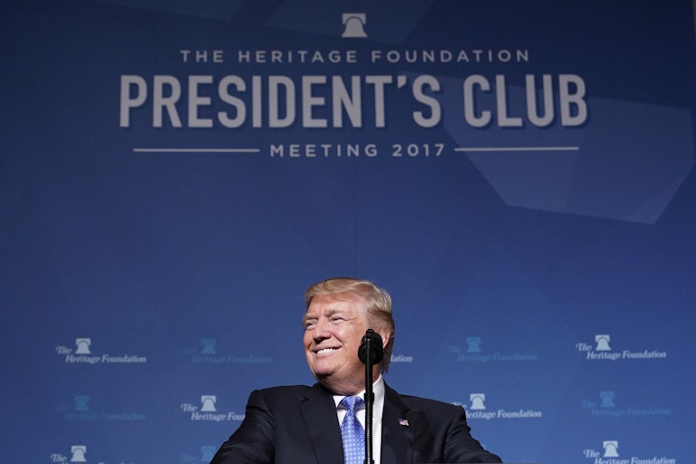 Donald Trump smiles as he stands behind a lectern at a Heritage Foundation event in 2017.