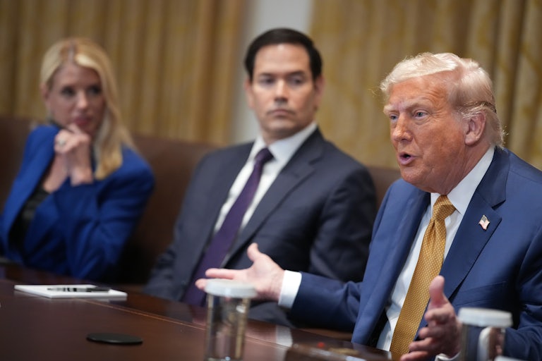Donald Trump splays his hands outward as he speaks during a Cabinet meeting. Secretary of State Marco Rubio is seated to the right of him, and Attorney General Pam Bondi to the right of Rubio.