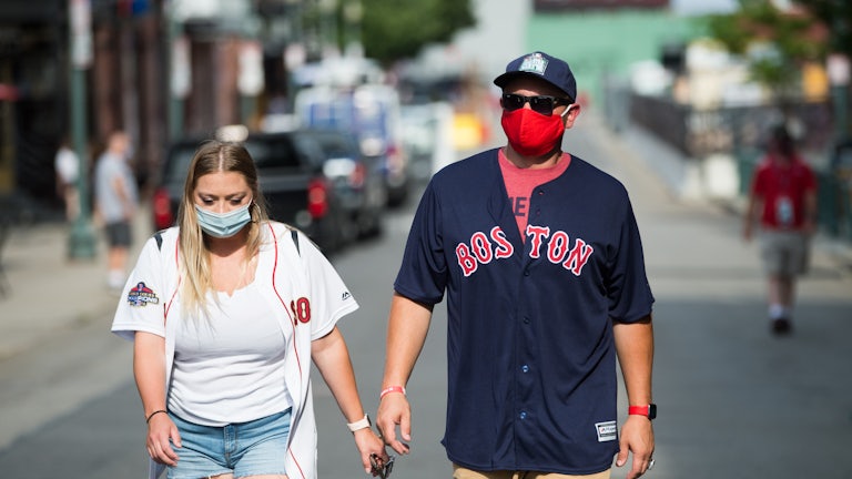 Fans wear masks on Landsdowne Street as they walk to Fenway Park in Boston.