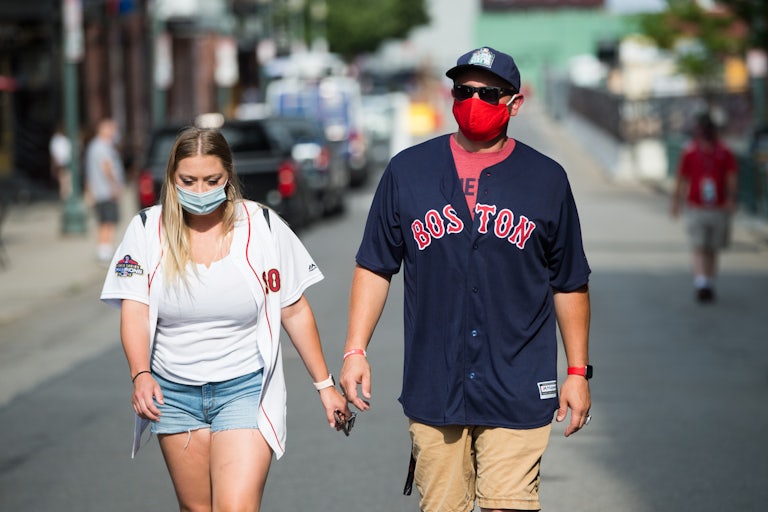 Fans wear masks on Landsdowne Street as they walk to Fenway Park in Boston.