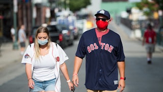 Fans wear masks on Landsdowne Street as they walk to Fenway Park in Boston.