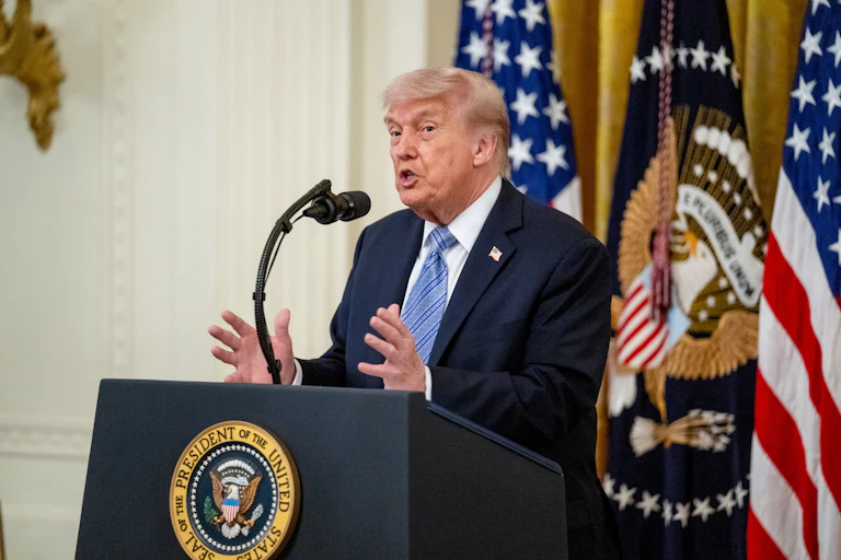 Donald Trump gestures and speaks at a podium