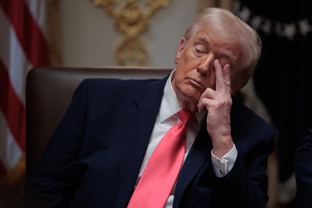 Donald Trump touches his eye with two fingers while sitting in his Cabinet meeting