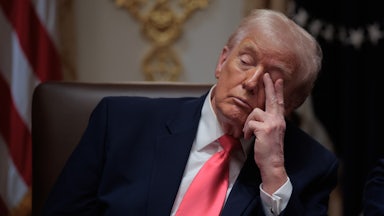 Donald Trump touches his eye with two fingers while sitting in his Cabinet meeting