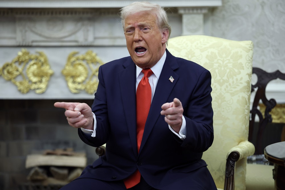 Donald Trump points and speaks while sitting in the Oval Office