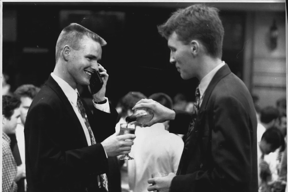 Accountants wearing expensive suits and using mobile phones at an after work drinks gathering in 1994