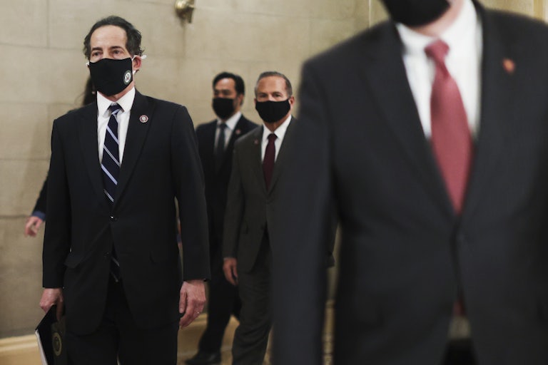 Representative Jamie Raskin of Maryland, in a mask, walks through the Capitol with the articles of impeachment.