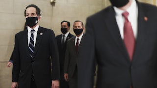 Representative Jamie Raskin of Maryland, in a mask, walks through the Capitol with the articles of impeachment.