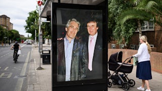 A photograph of Donald Trump and convicted child sex offender Jeffrey Epstein is displayed in a bus shelter in London. Others walk around.