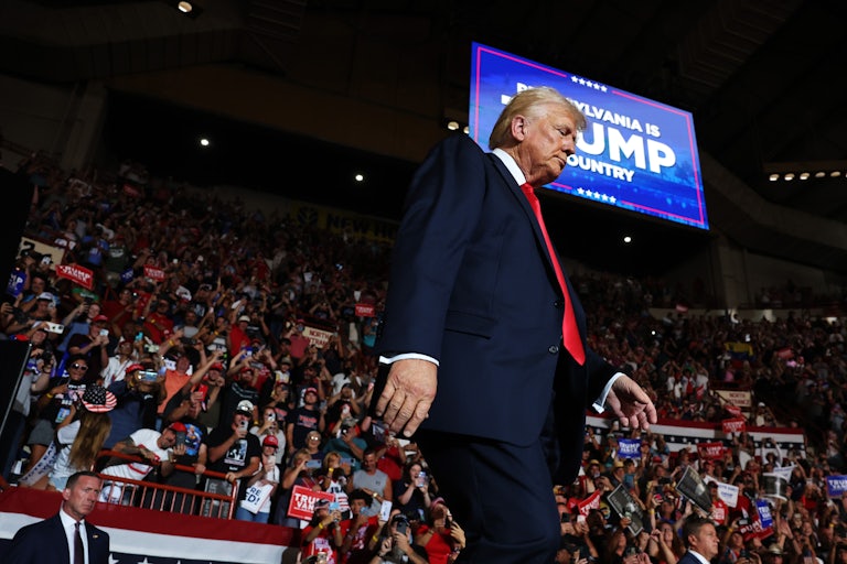 Donald Trump looks down as he walks at a campaign rally