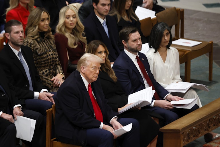 Donald Trump, Melania Trump, JD Vance, and Usha Vance seated in one pew at the inaugural prayer. Other Trump family members sit behind them.