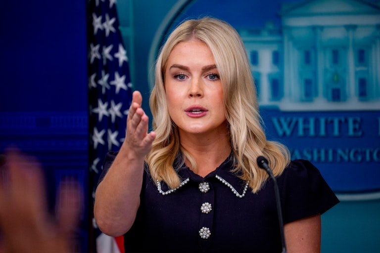 White House press secretary Karoline Leavitt gestures while speaking at the podium in the White House press briefing room