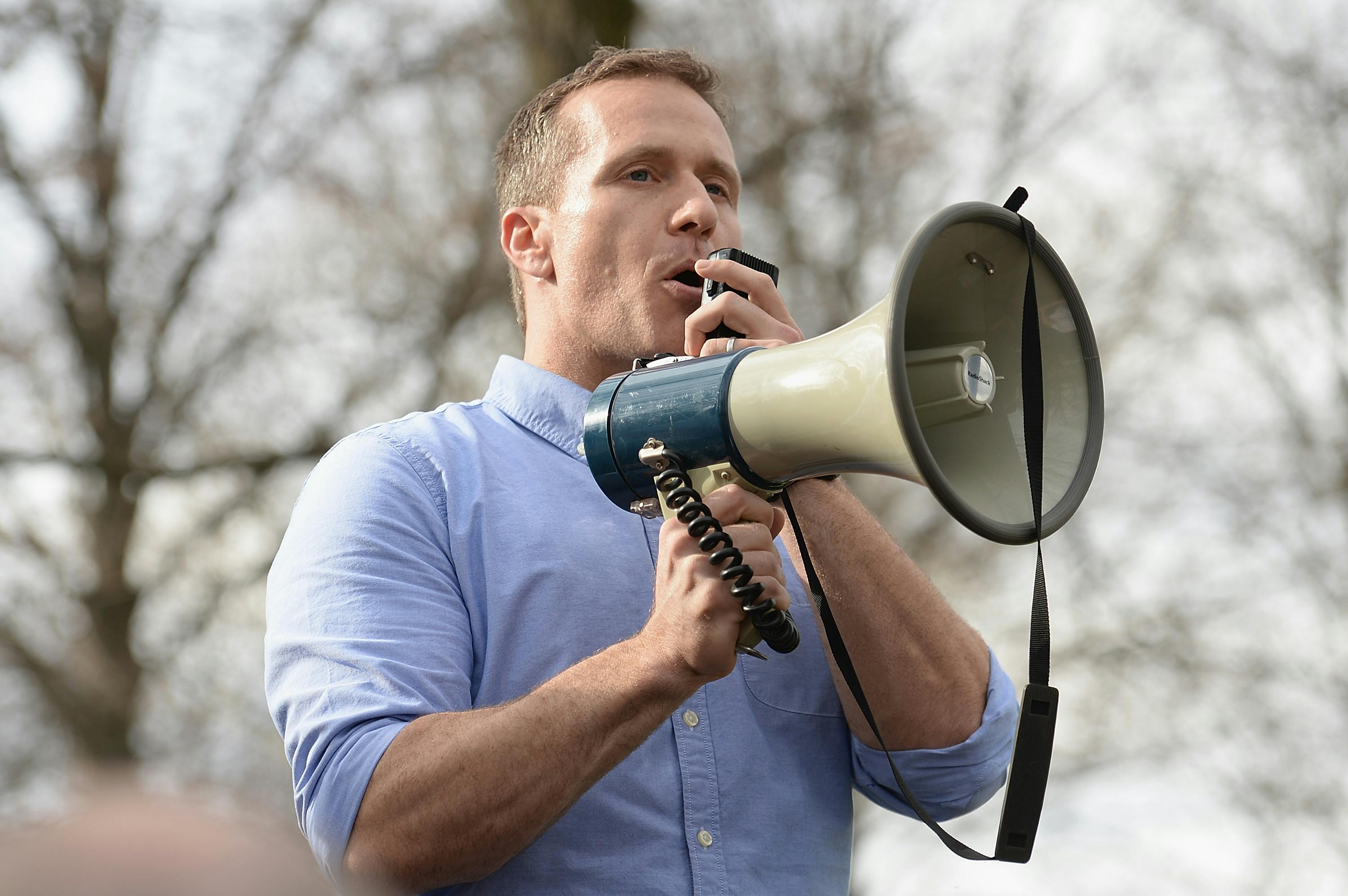 Former Missouri Governor Eric Greitens speaks through a megaphone.