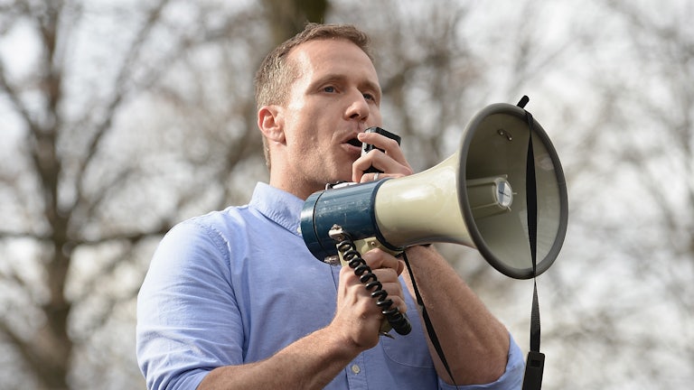 Former Missouri Governor Eric Greitens speaks through a megaphone.