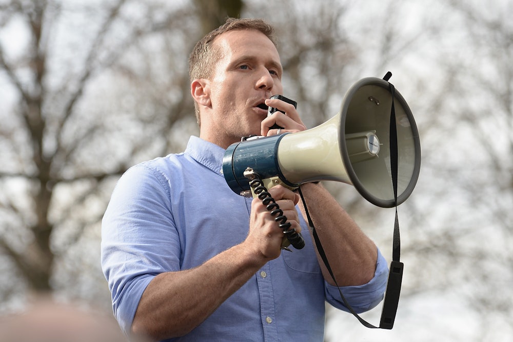 Former Missouri Governor Eric Greitens speaks through a megaphone.