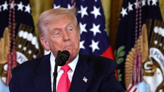 Donald Trump pulls the corners of his mouth down as he stands at a microphone