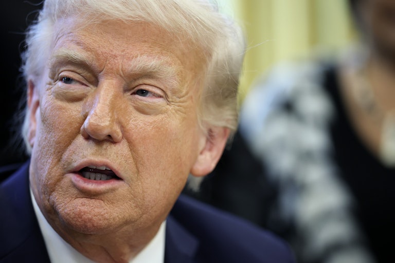 Donald Trump turns his head and speaks while narrowing his eyes.