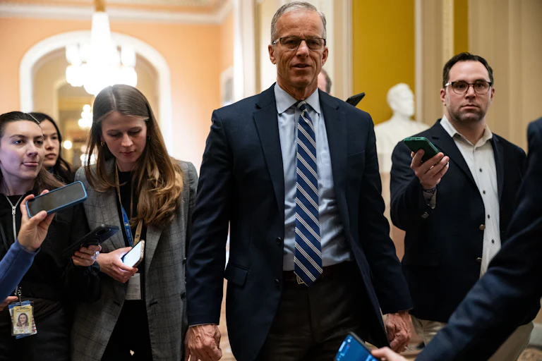 Senate Majority Leader John Thune walks in the Capitol as reporters surround him