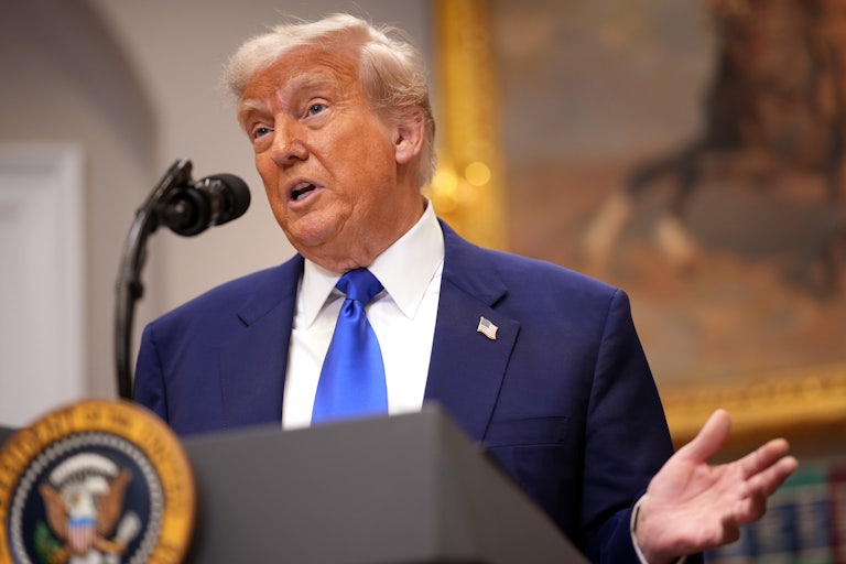 Donald Trump gestures while speaking at a podium in the Oval Office