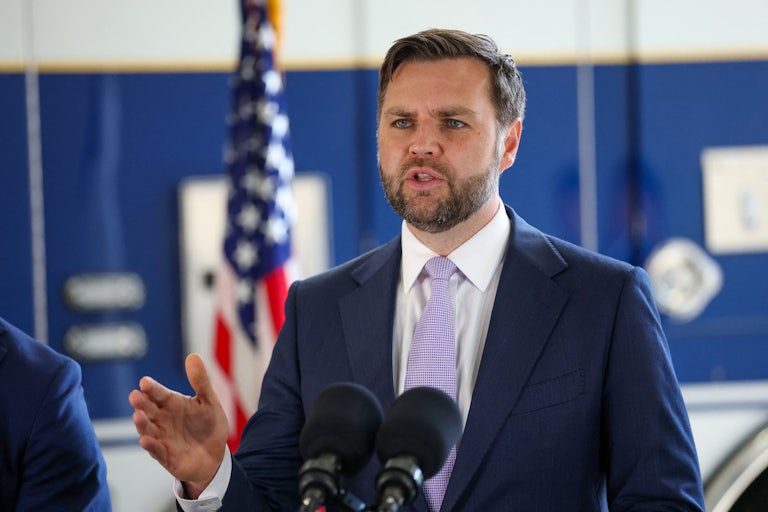 Vice President JD Vance gestures while speaking into microphones