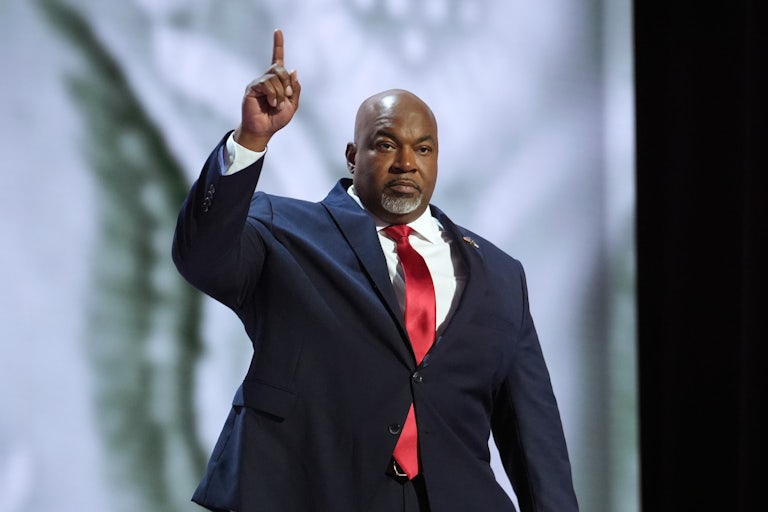 Mark Robinson holds up one finger as he walks on stage at the Republican National Convention
