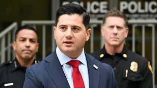 First Assistant U.S. Attorney for the Central District of California Bill Essayli speaks with two police officers behind him