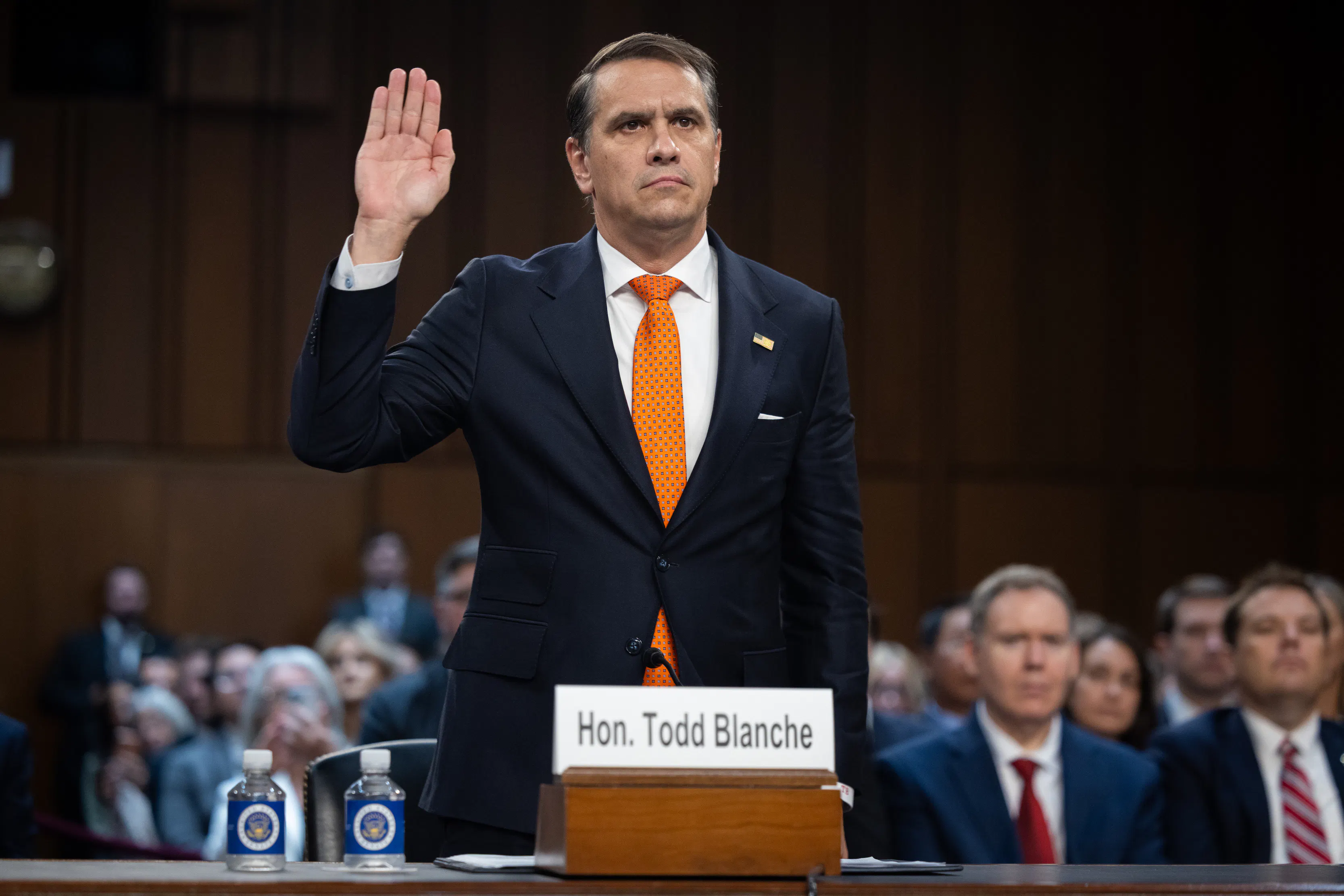 Acting Attorney General Todd Blanche raises his hand while standing in his Senate committee confirmation hearing