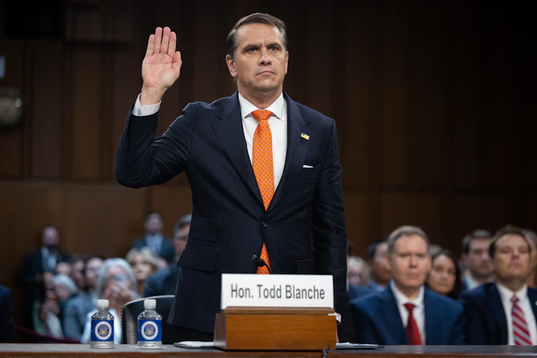 Acting Attorney General Todd Blanche raises his hand while standing in his Senate committee confirmation hearing