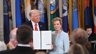 Donald Trump holds a signed executive order as he poses alongside Education Secretary Linda McMahon.