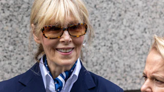E. Jean Carroll smiles while walking out of a New York City courthouse