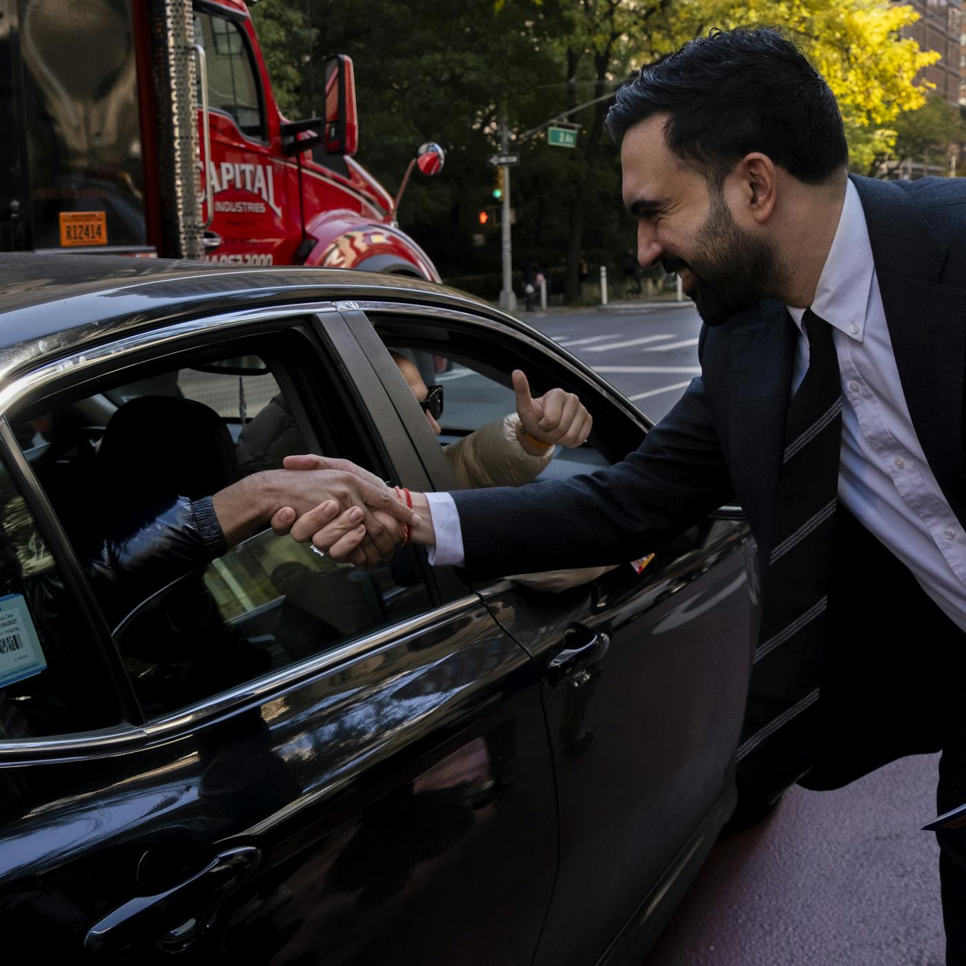 Mamdani shakes supporters hand in car