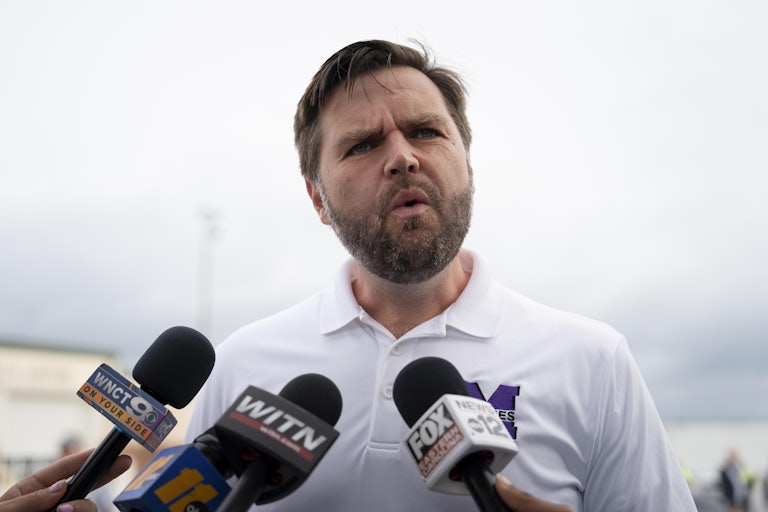 J.D. Vance speaks into reporters’ microphones