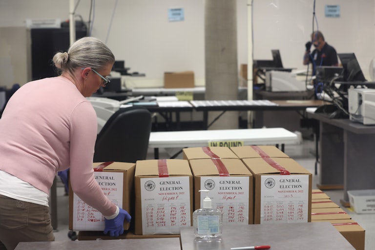 An election worker places a box of scanned ballots on a pallet at the Maricopa County Tabulation and Election Center in Phoenix, Arizona.
