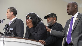 RowVaugn Wells has her head in her hands, covering her face with a tissue.