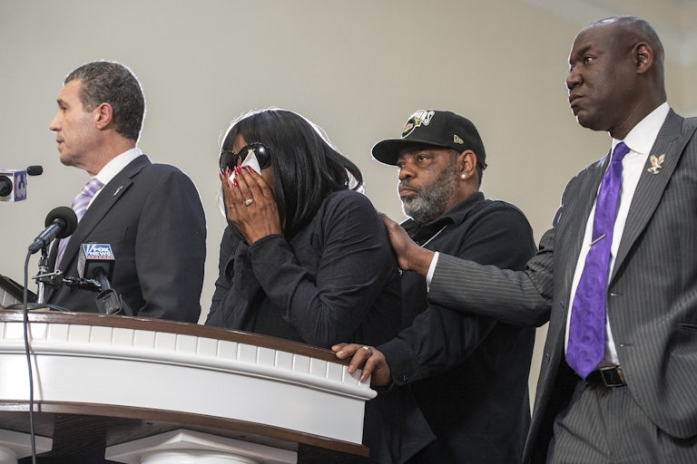RowVaugn Wells has her head in her hands, covering her face with a tissue.
