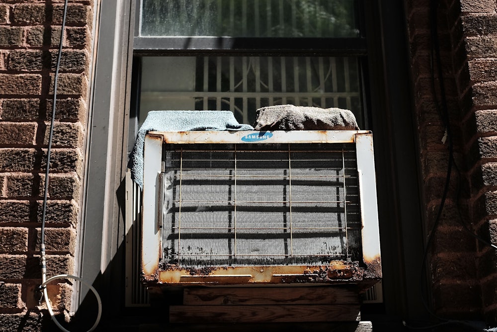 A rusty air conditioner sits in a window.