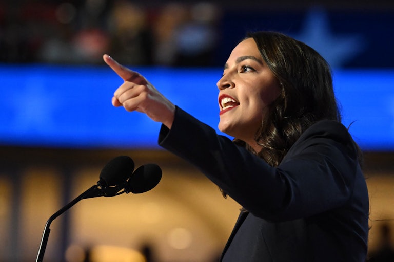 Representative Alexandria Ocasio-Cortez speaks at a lectern.