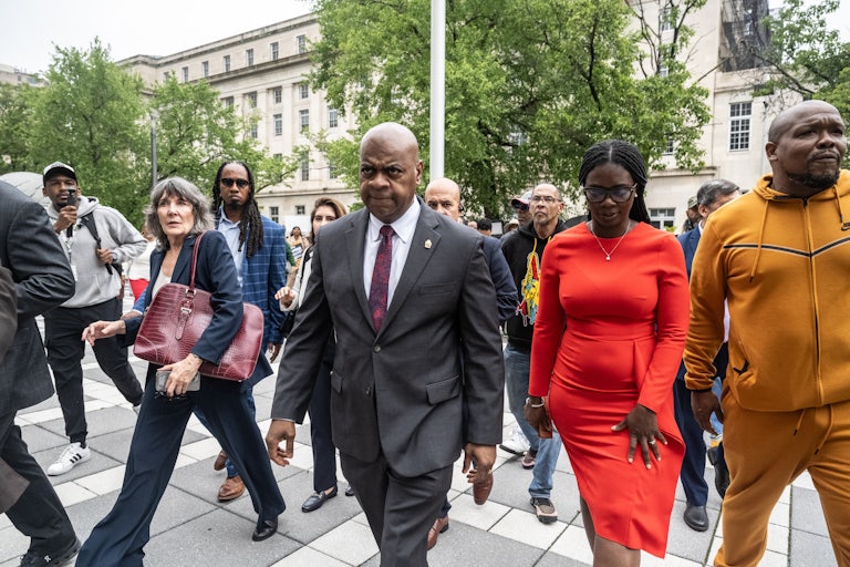 Newark Mayor Ras Baraka exits the courthouse as others walk alongside him.